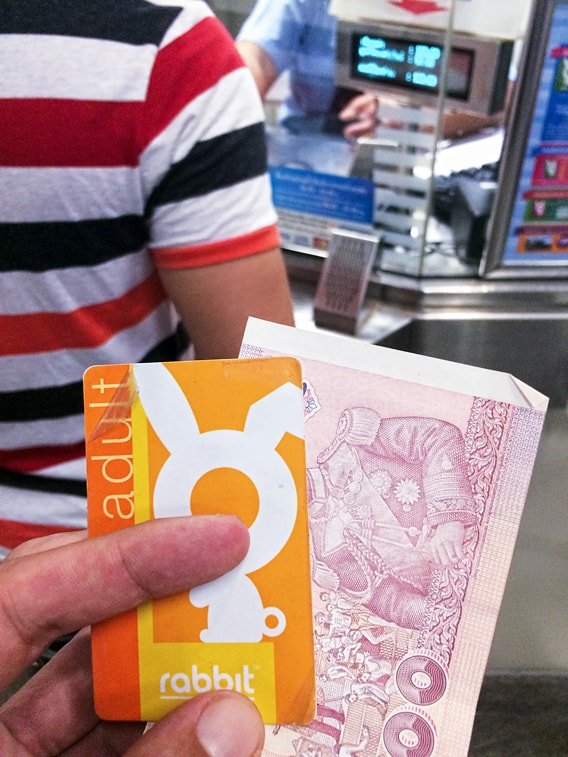 Aufladen der Rabbit Card an der Kasse einer Skytrain Station in Bangkok