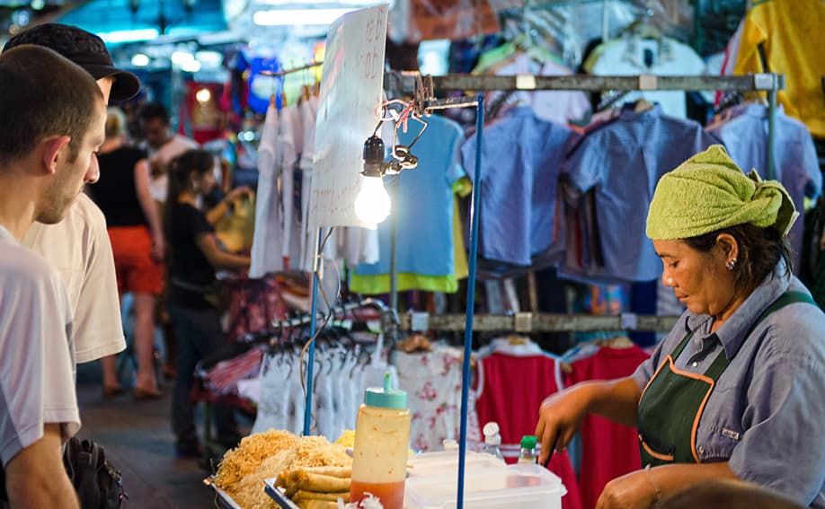 Rucksacktouristen vor einer Garküche in der Khao San Road.