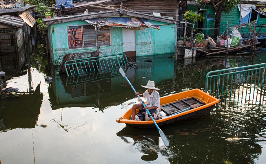 Mann im Boot auf einer Straße in Thailand