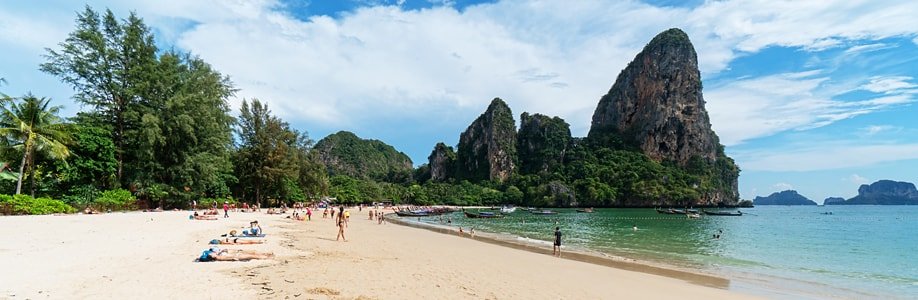 Longtailboote und Urlauber am Railay West Beach.