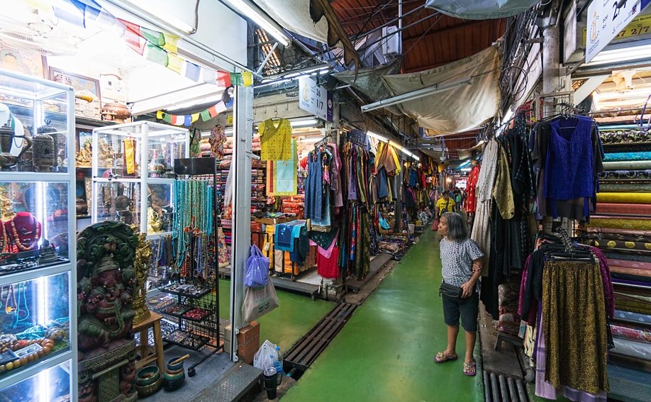 Marktstände mit Schmuck, Kleidung und Stoffen.