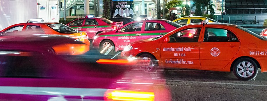 Bunte Taxis bei Nacht in Bangkok
