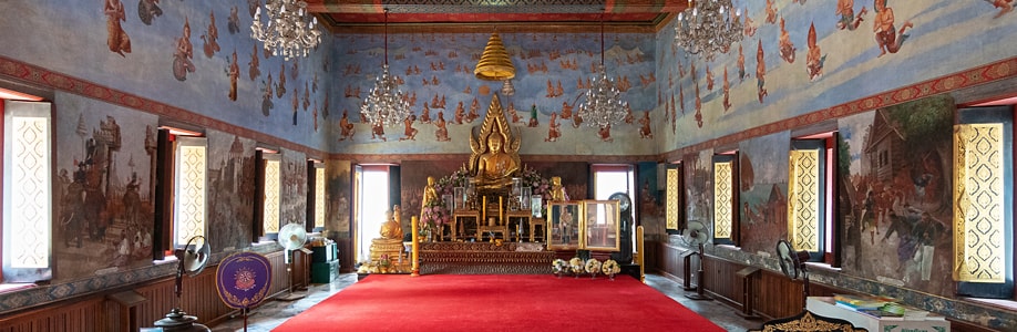 Buddha-Statue und Wandmalereien im Wat Suwan Dararam.