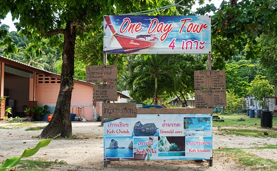 Stand einer Touristeninformation auf Koh Ngai, an dem für die 4-Island-Tour und andere Ausflüge geworben wird.